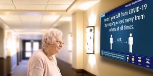 senior looking at digital bulletin board at retirement home